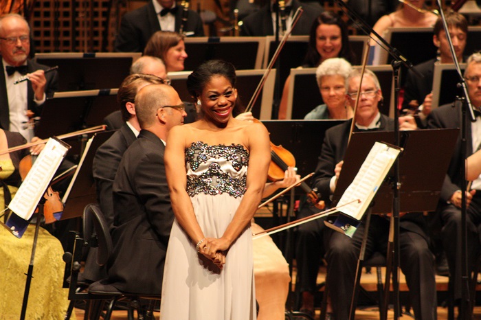 A woman on the scene in front of the orchestra